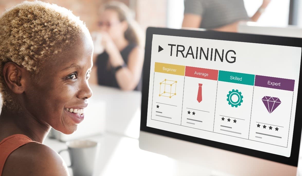 A smiling learner following a training session on a computer